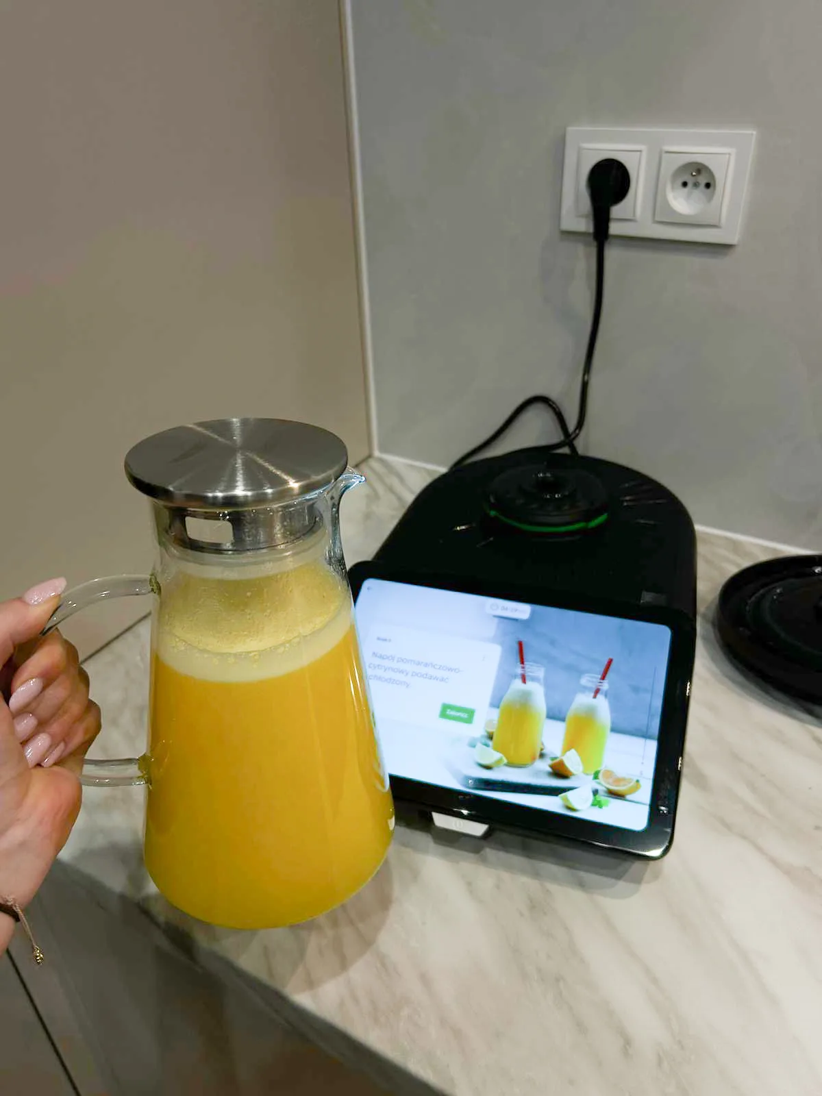 Domowa lemoniada przygotowana w Thermomixie TM7, obok urządzenie z przepisem na ekranie